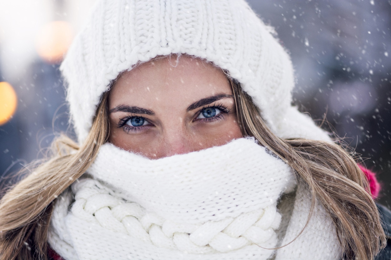 Beautiful girl posing outdoors while snowing